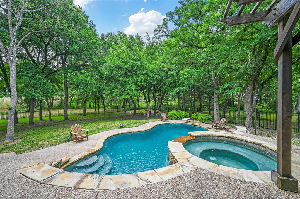 a view of a swimming pool with a patio and a yard