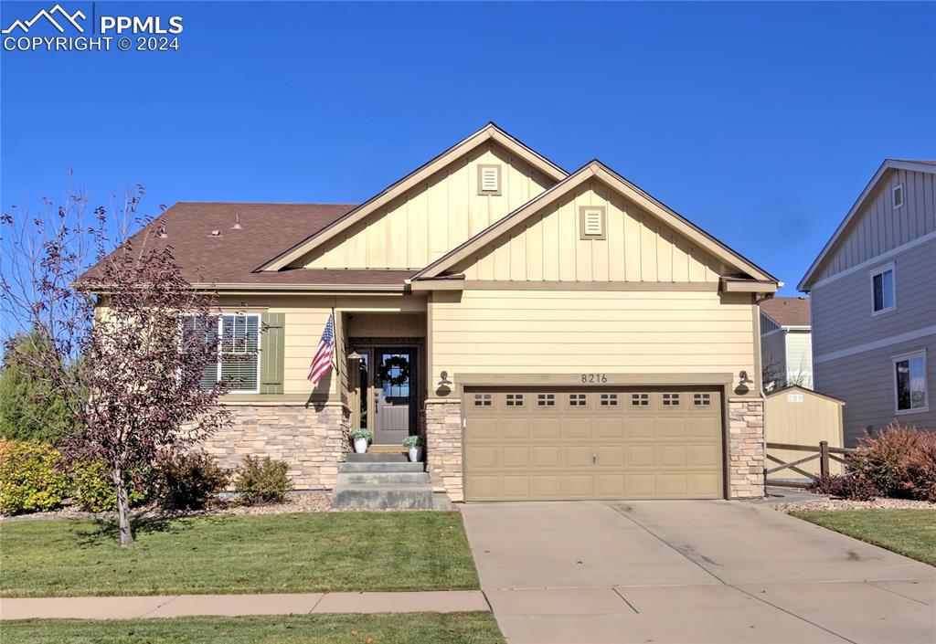 Craftsman-style home featuring a front yard and a garage