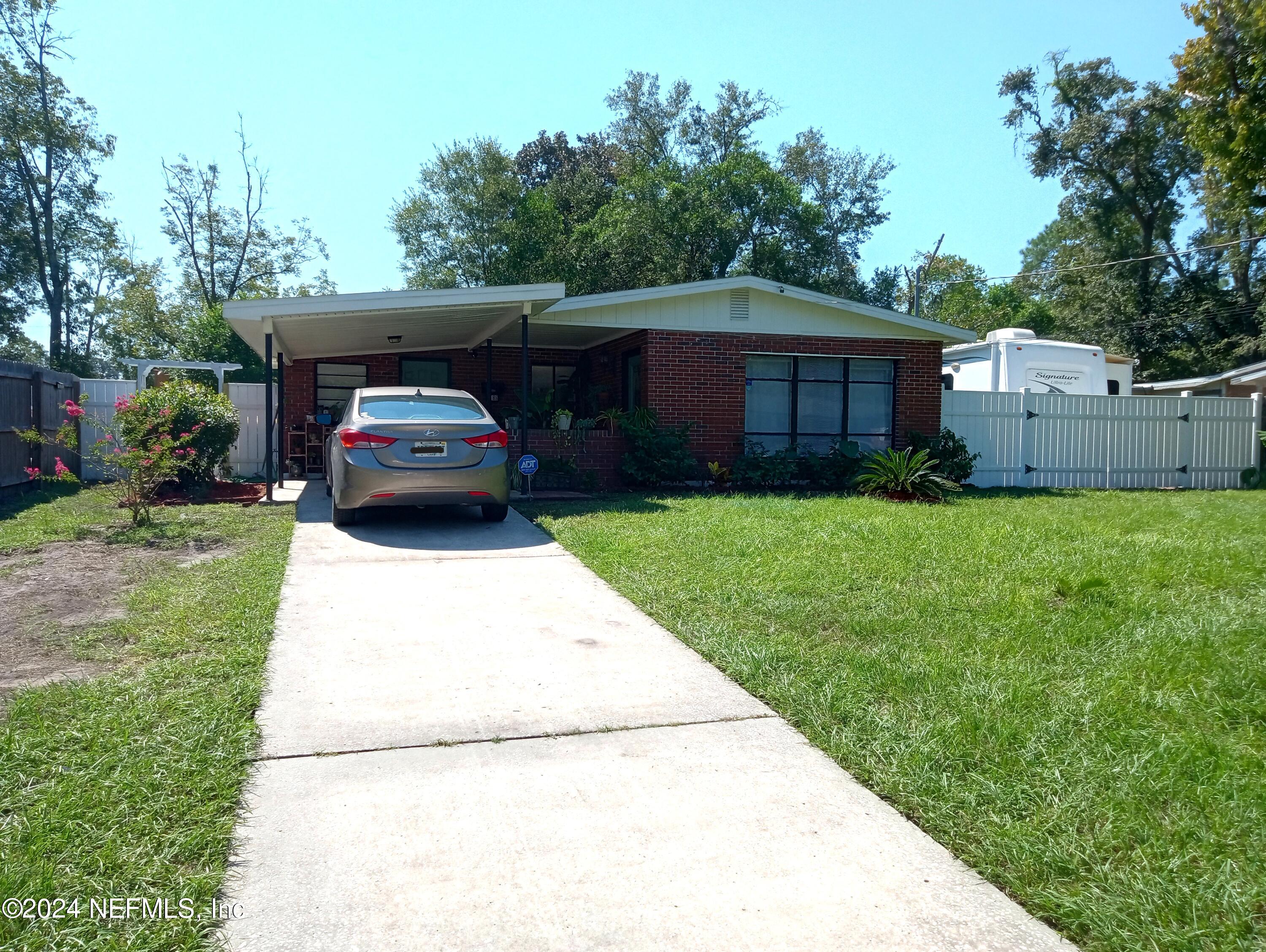 a car parked in front of a house with a yard