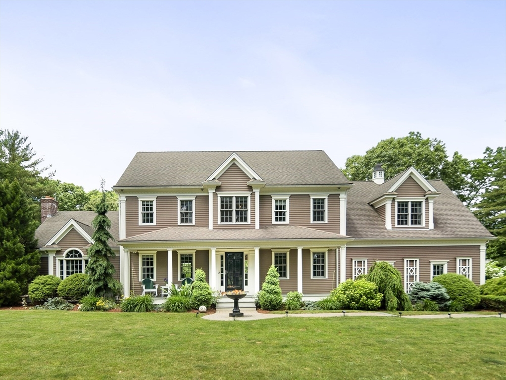 a front view of a house with a yard and potted plants