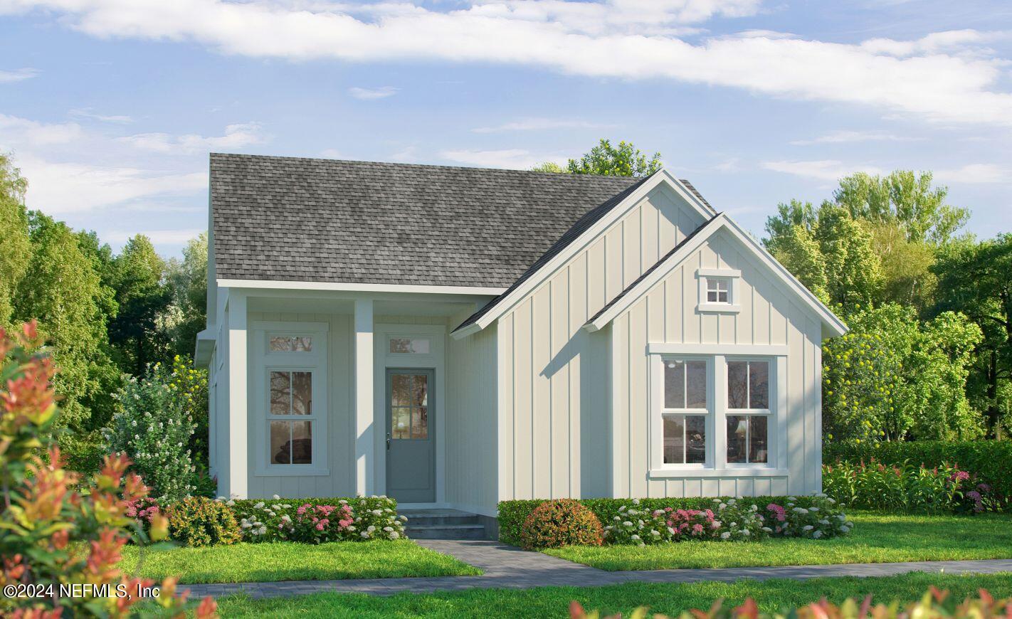 a front view of a house with a yard and potted plants