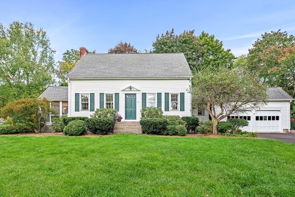 a front view of a house with a yard and trees