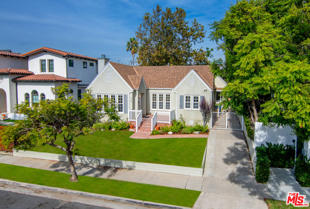 a front view of a house with a yard and potted plants