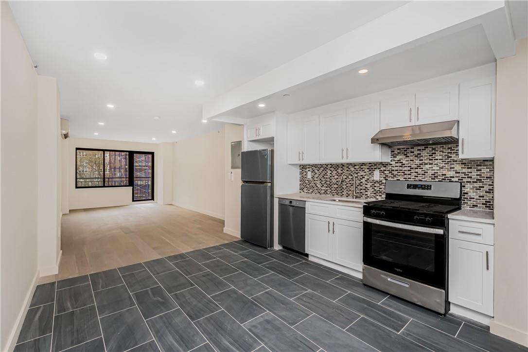 Kitchen featuring white cabinets, decorative backsplash, sink, dark hardwood / wood-style floors, and appliances with stainless steel finishes