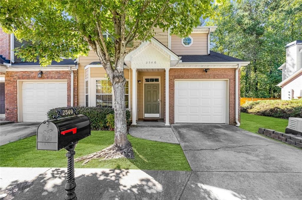 a front view of a house with a yard and garage