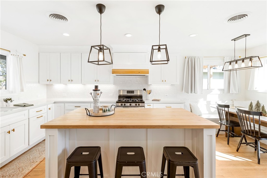 a kitchen with a sink a stove and chairs