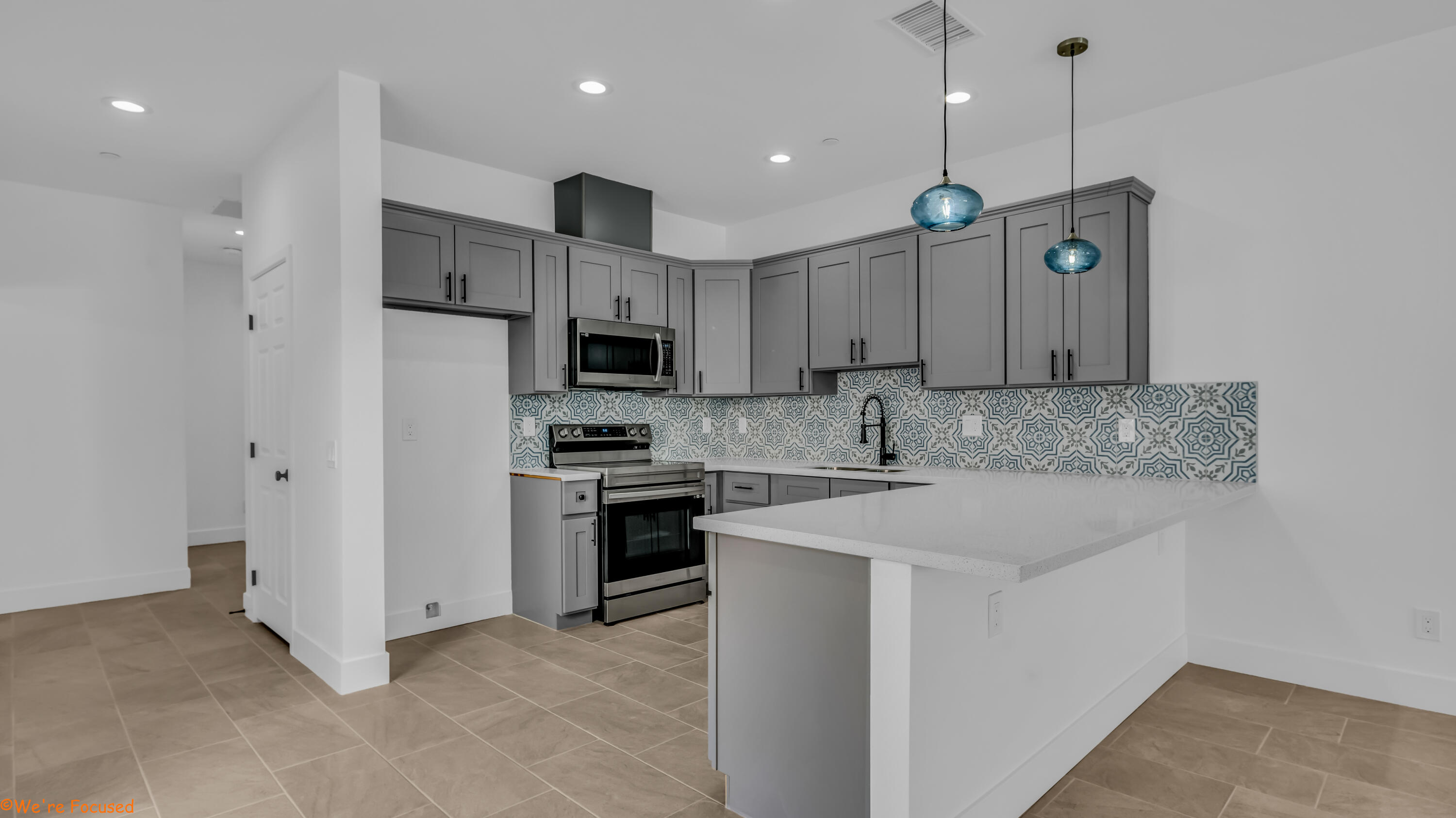 a kitchen with kitchen island white cabinets and stainless steel appliances