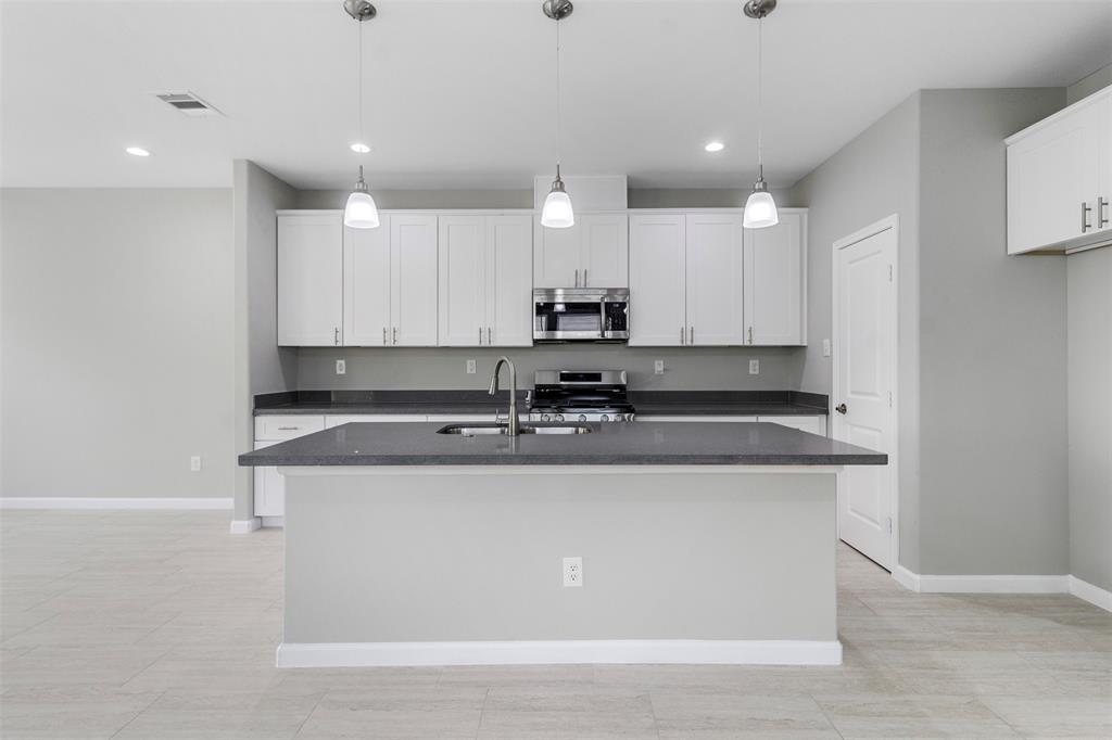 a view of kitchen with stainless steel appliances granite countertop cabinets and sink