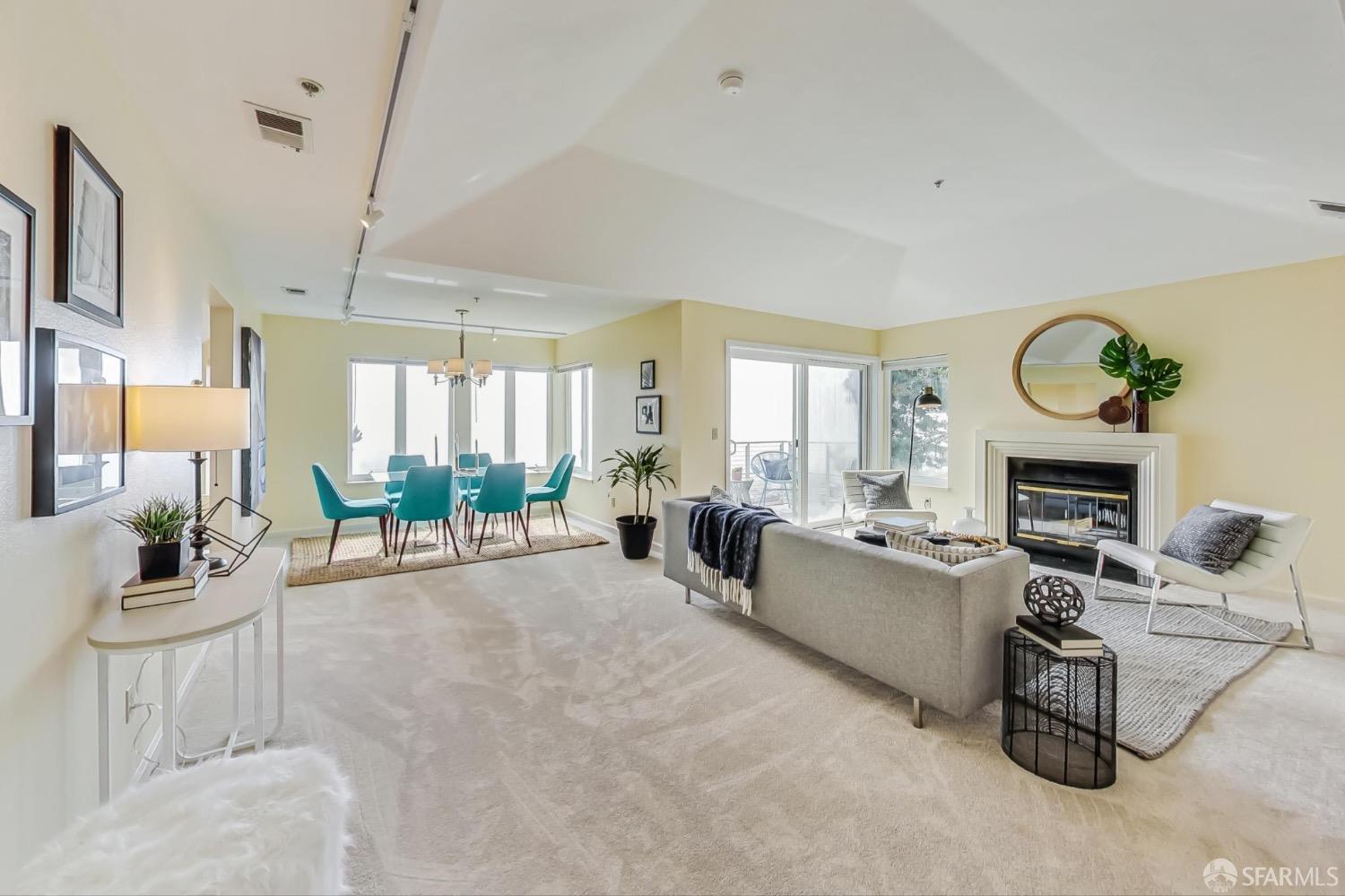 a living room with furniture a fireplace and a floor to ceiling window