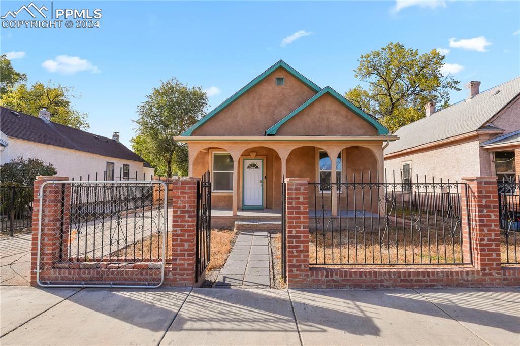 a view of a house with wooden fence next to a road