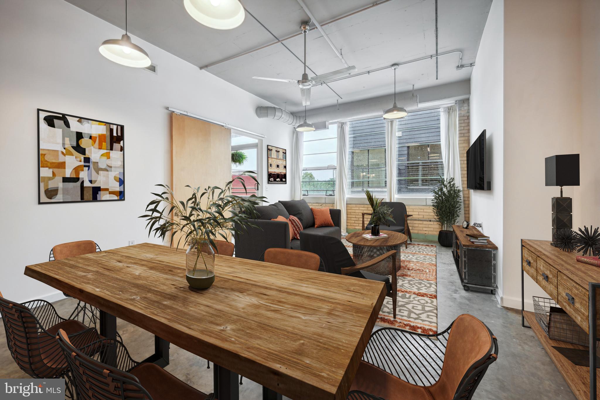 a living room with furniture a flat screen tv and a large window