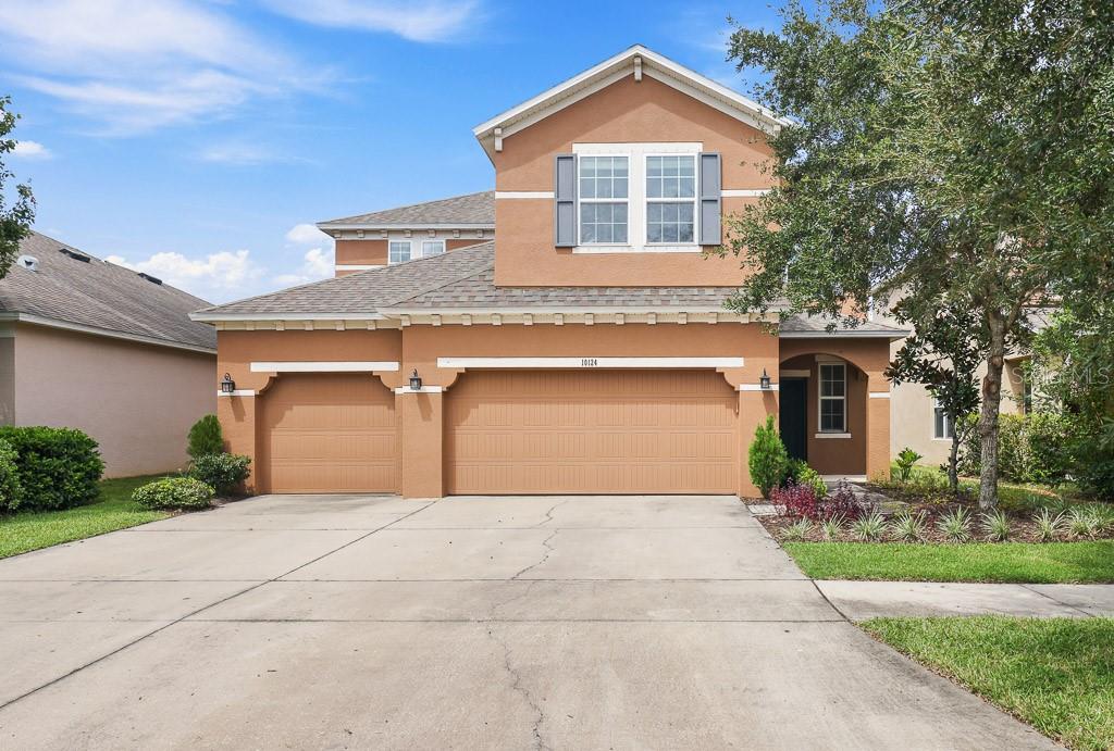 a front view of a house with a yard and garage