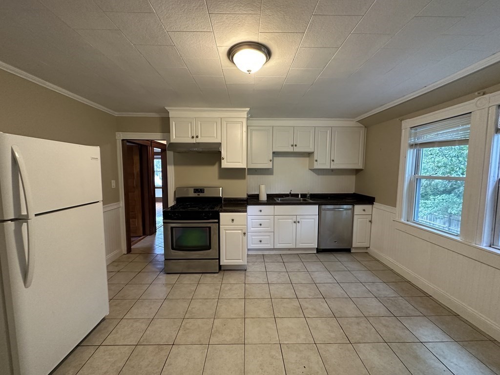 a kitchen with stainless steel appliances a refrigerator sink and cabinets