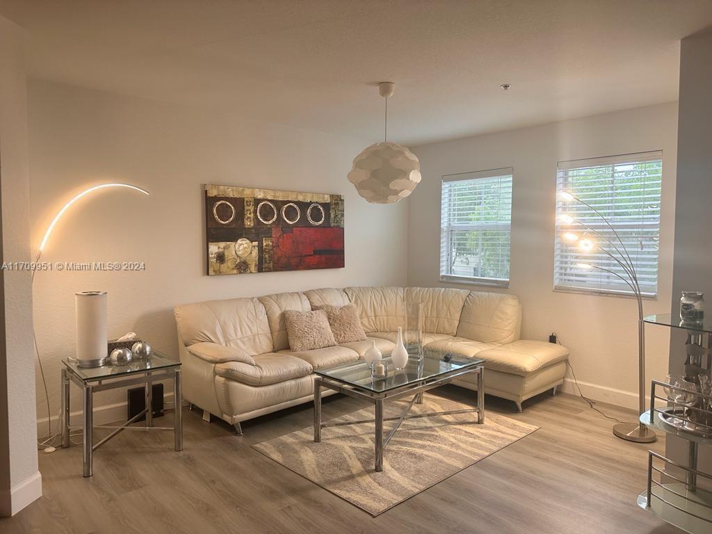 a living room with furniture and a wooden floor