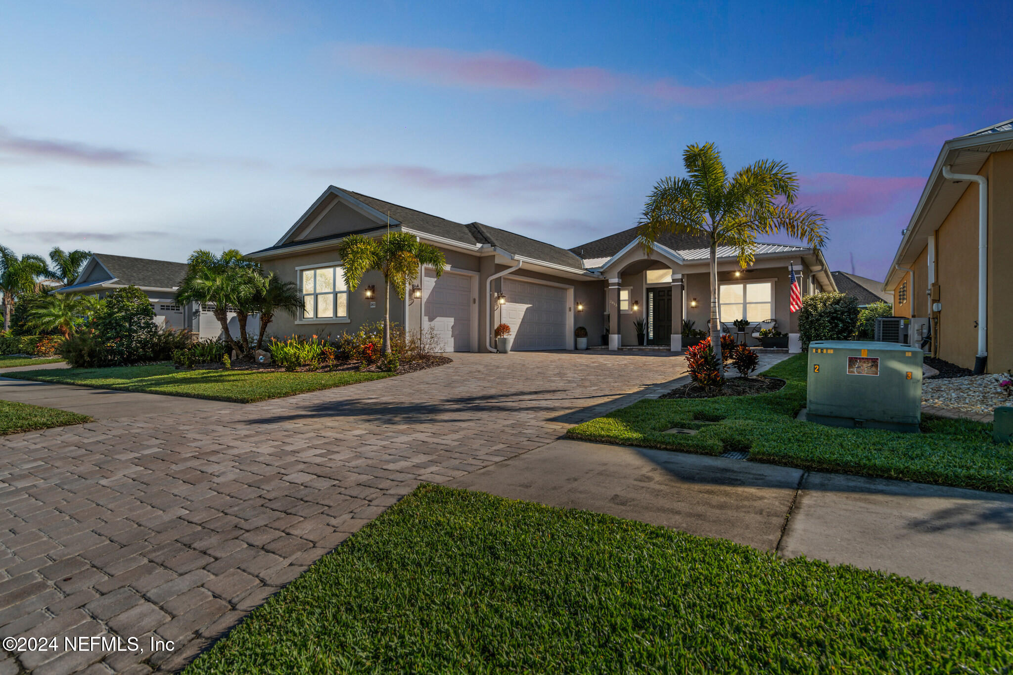 a front view of a house with a yard and potted plants