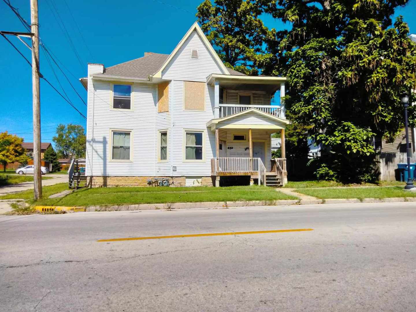 a front view of a house with a yard and road