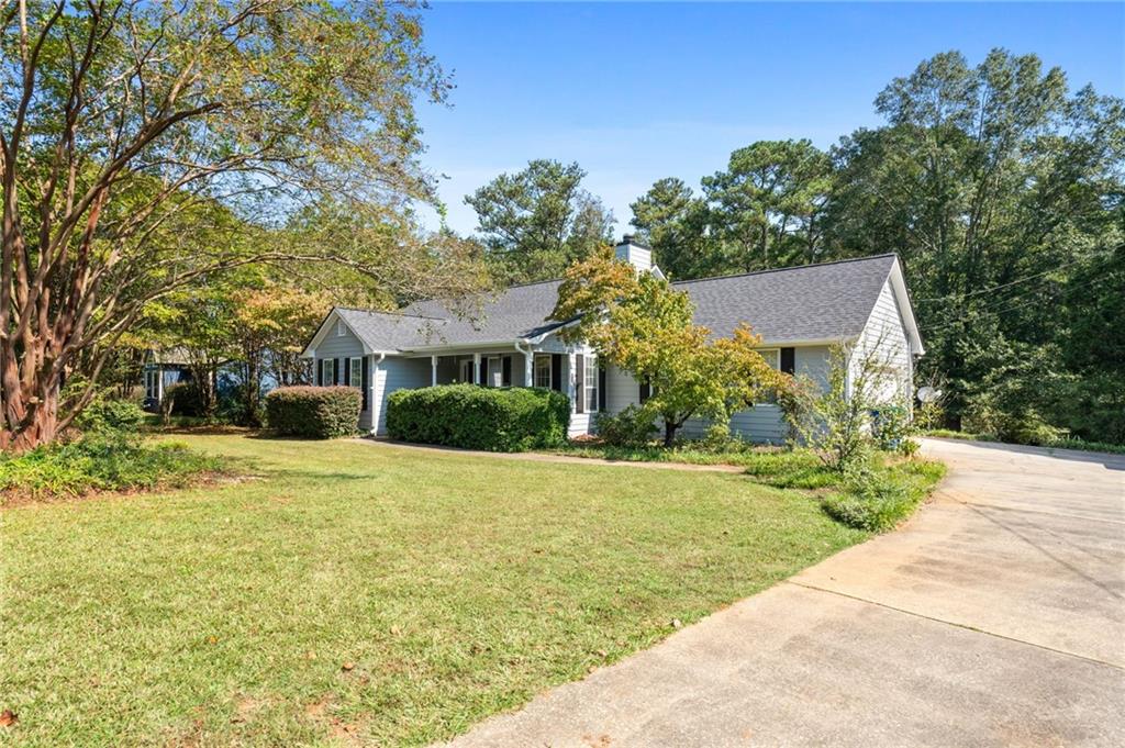 a front view of a house with a yard and trees