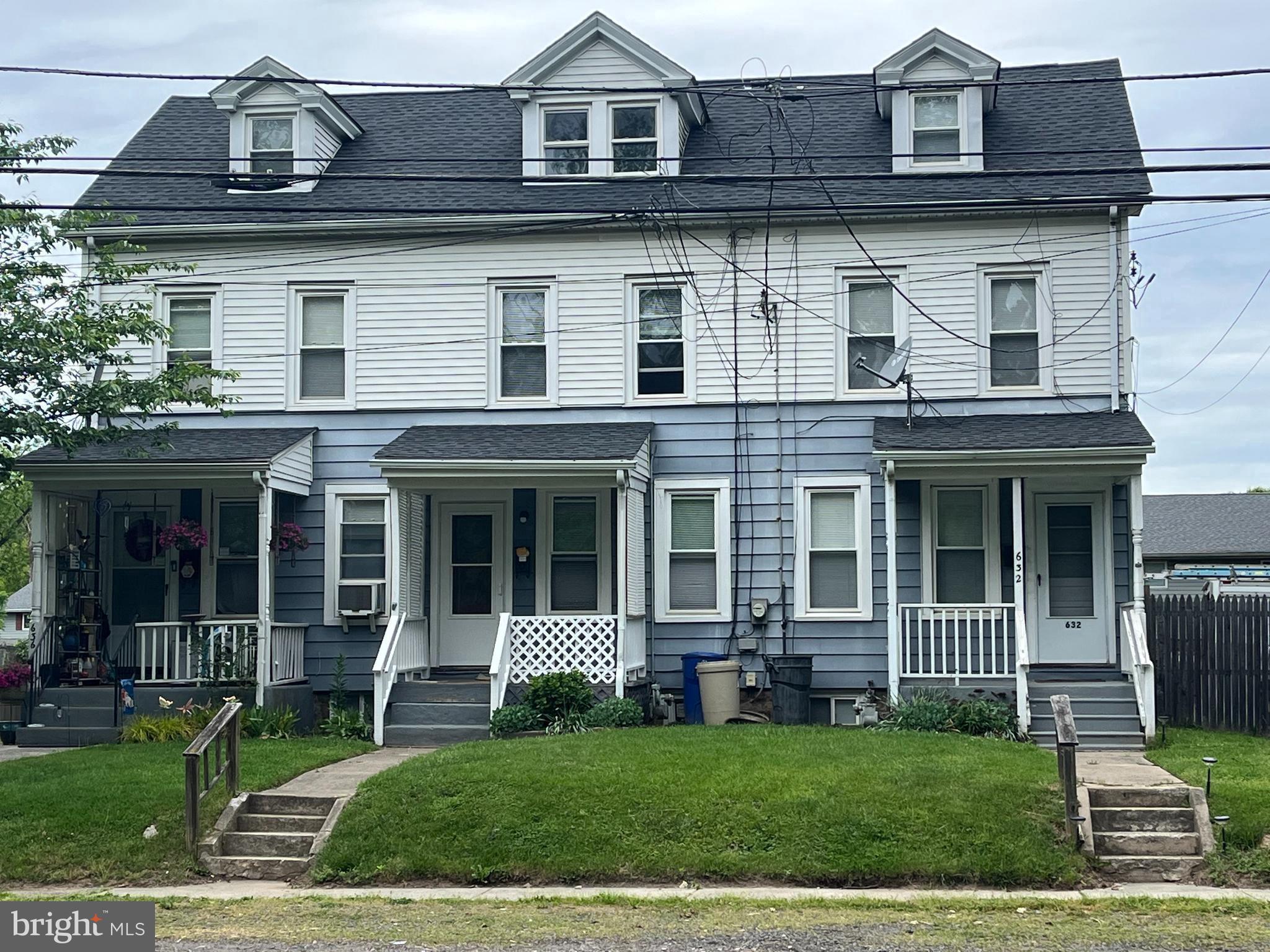 a view of a brick house with large windows and a yard