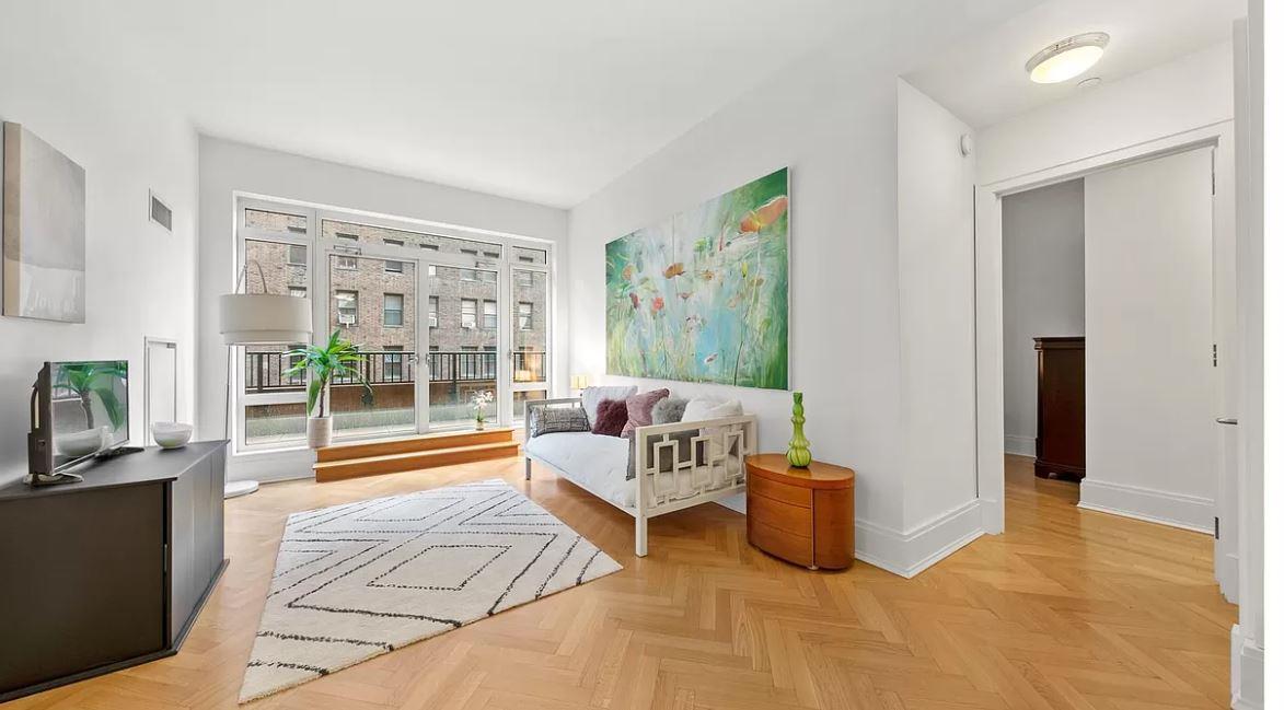 a living room with furniture and a floor to ceiling window