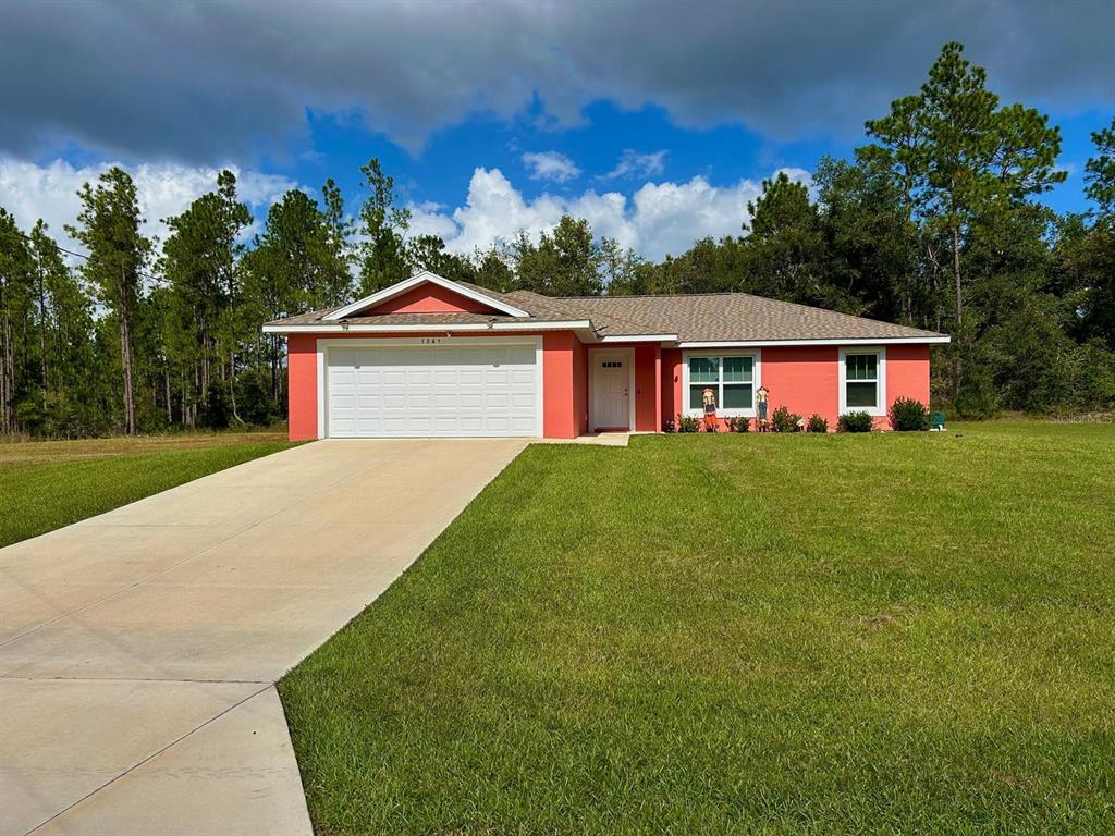 a front view of a house with a yard and trees