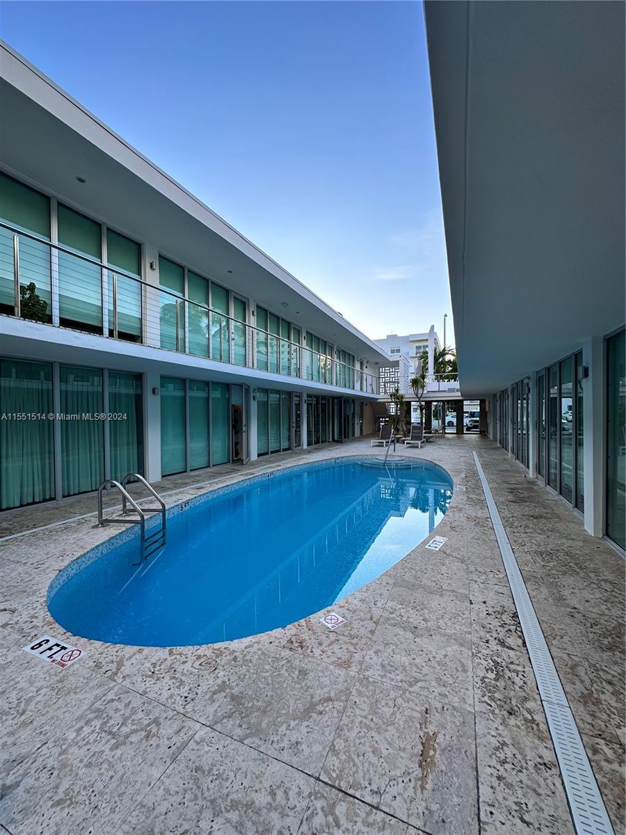 a view of a house with swimming pool and sitting area