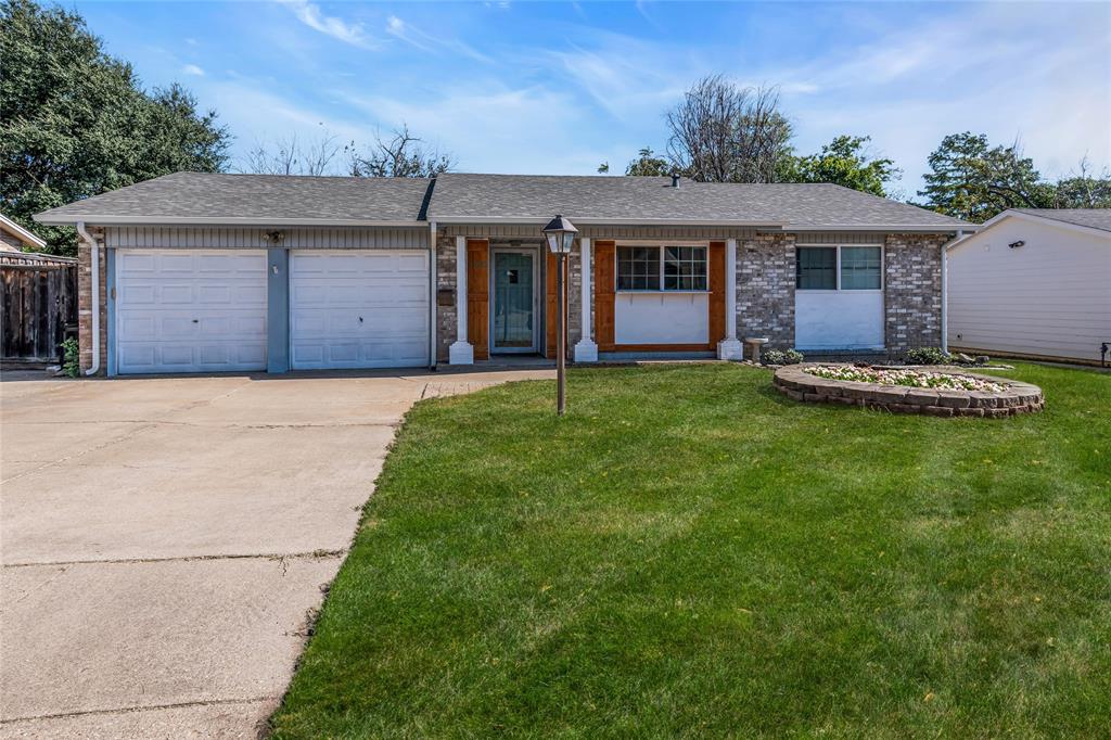 Single story home featuring a front yard and a garage