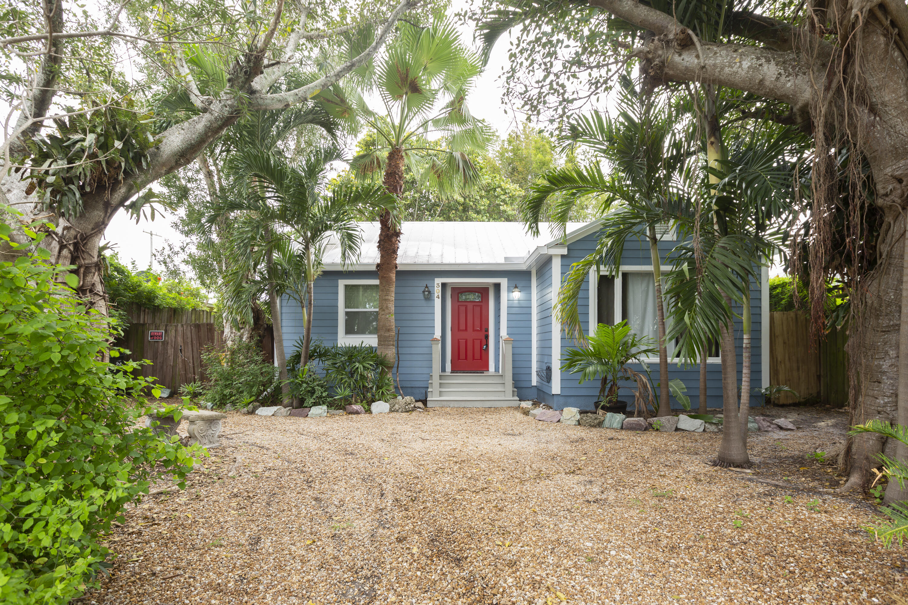 a front view of a house with garden and trees