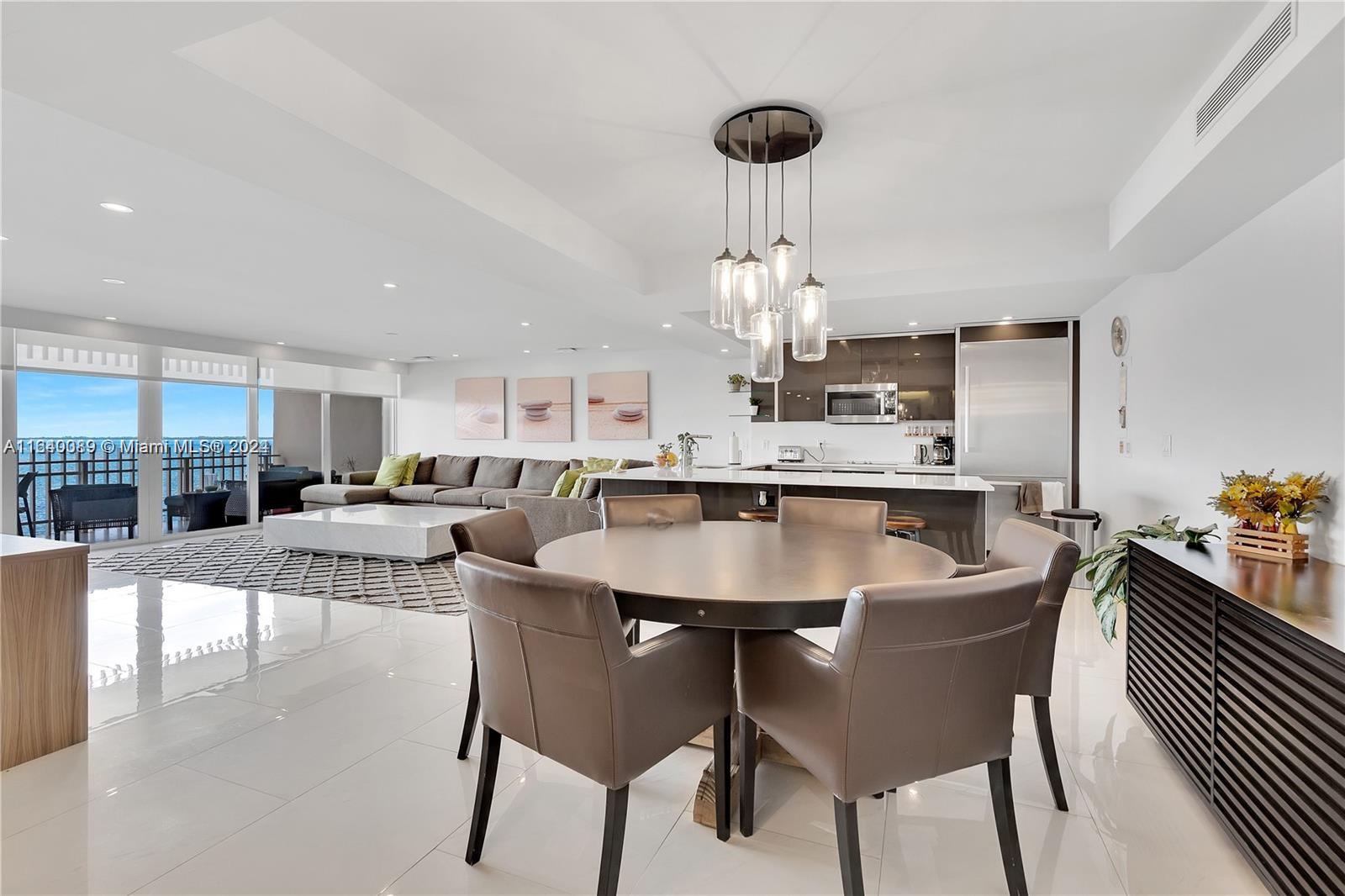 a dining table with chairs and kitchen view