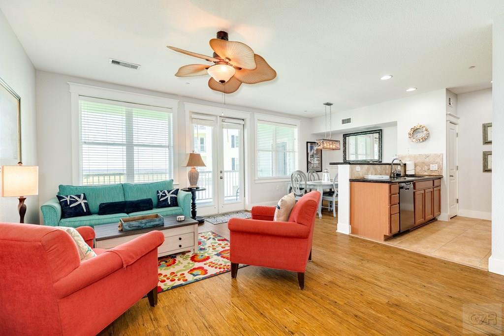 a living room with furniture kitchen view and a large window