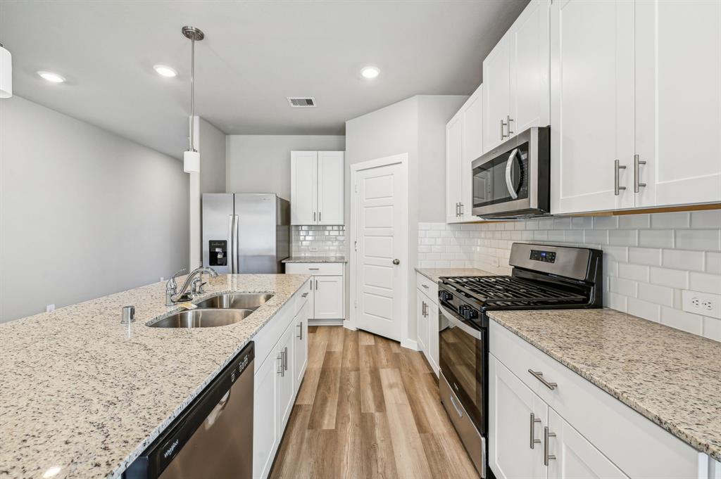 a kitchen with a sink stove and cabinets