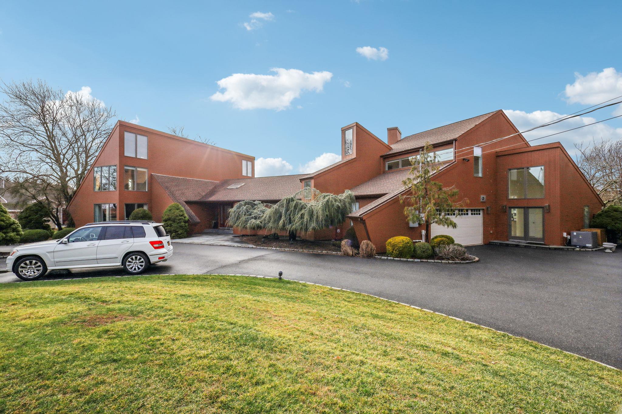 View of building exterior featuring cooling unit and a garage