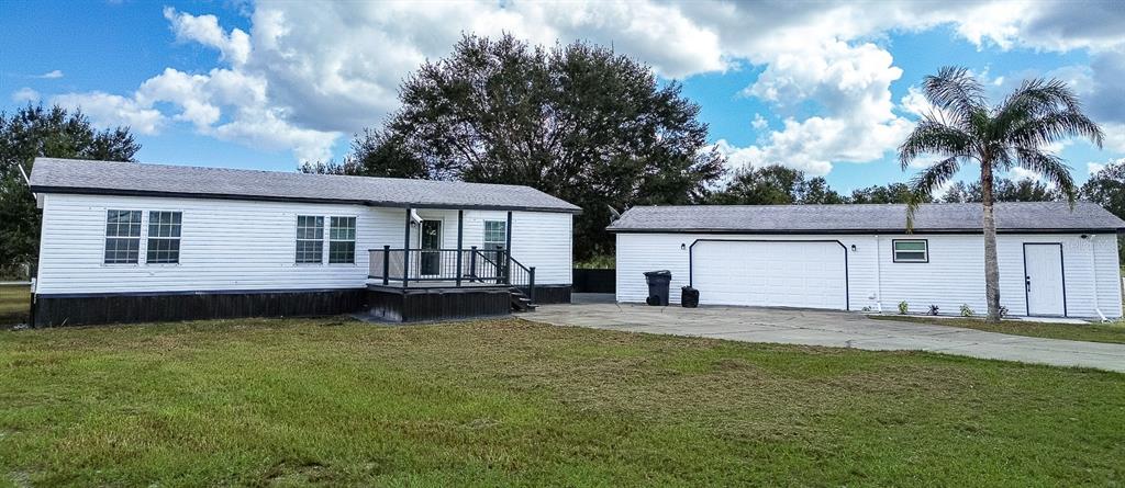 a view of a house with a patio and a yard