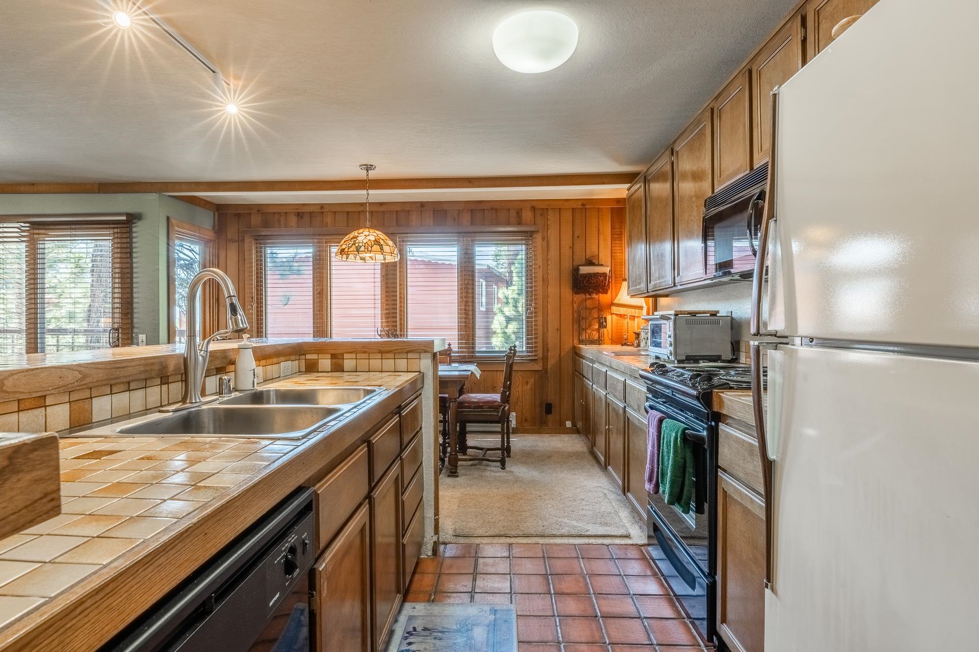 a large kitchen with stainless steel appliances granite countertop a refrigerator and a sink