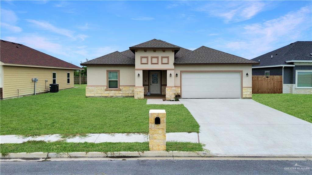 a front view of a house with a yard and garage