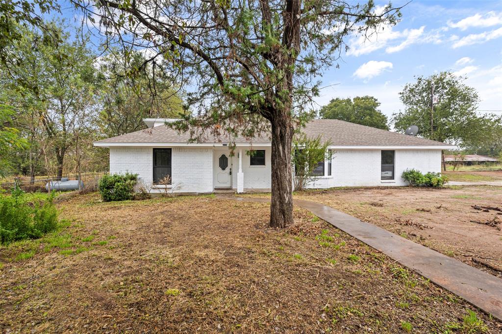 a view of a house with a tree in the yard