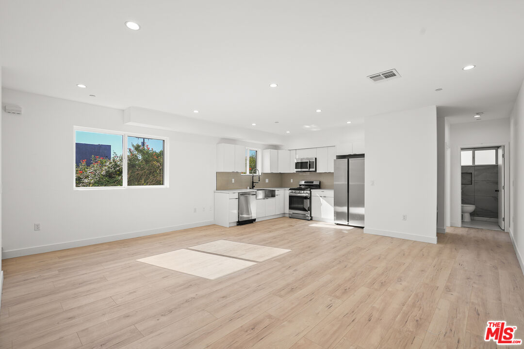 a view of kitchen with wooden floor and electronic appliances