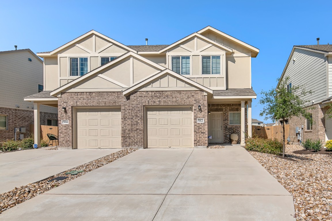 a front view of a house with yard and parking