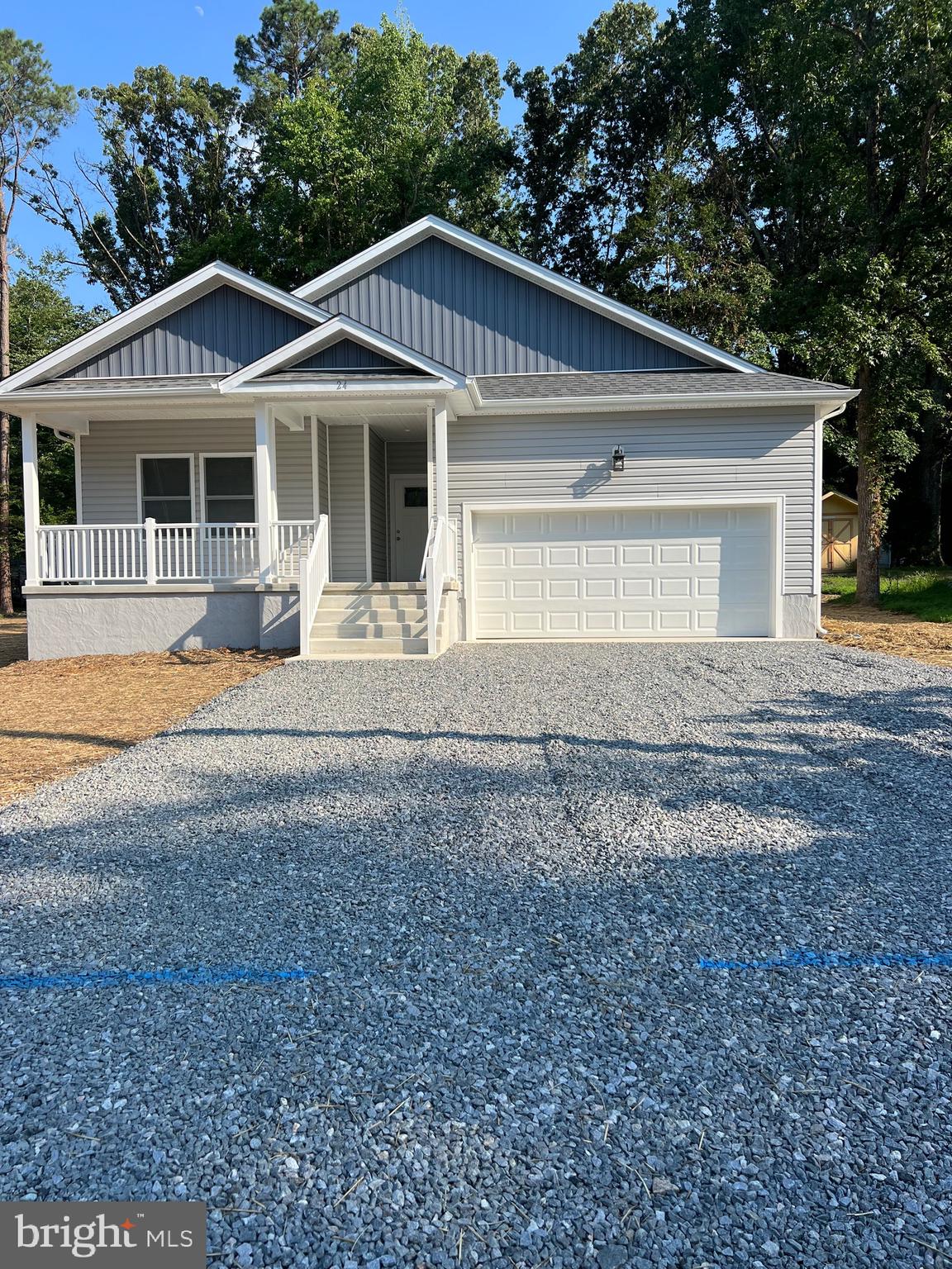 a front view of a house with a garden and trees