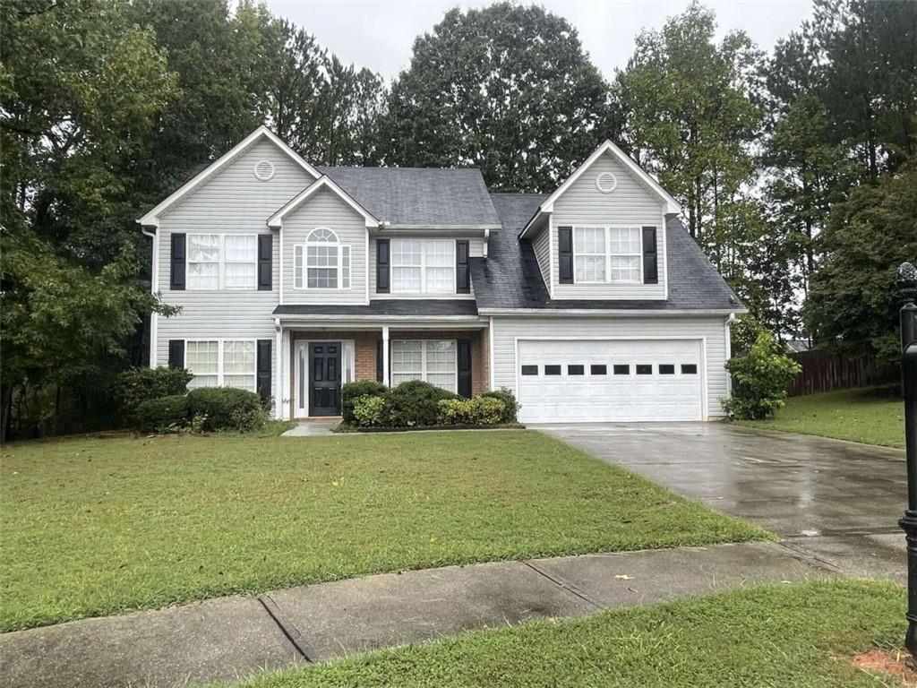 a front view of a house with a garden and yard