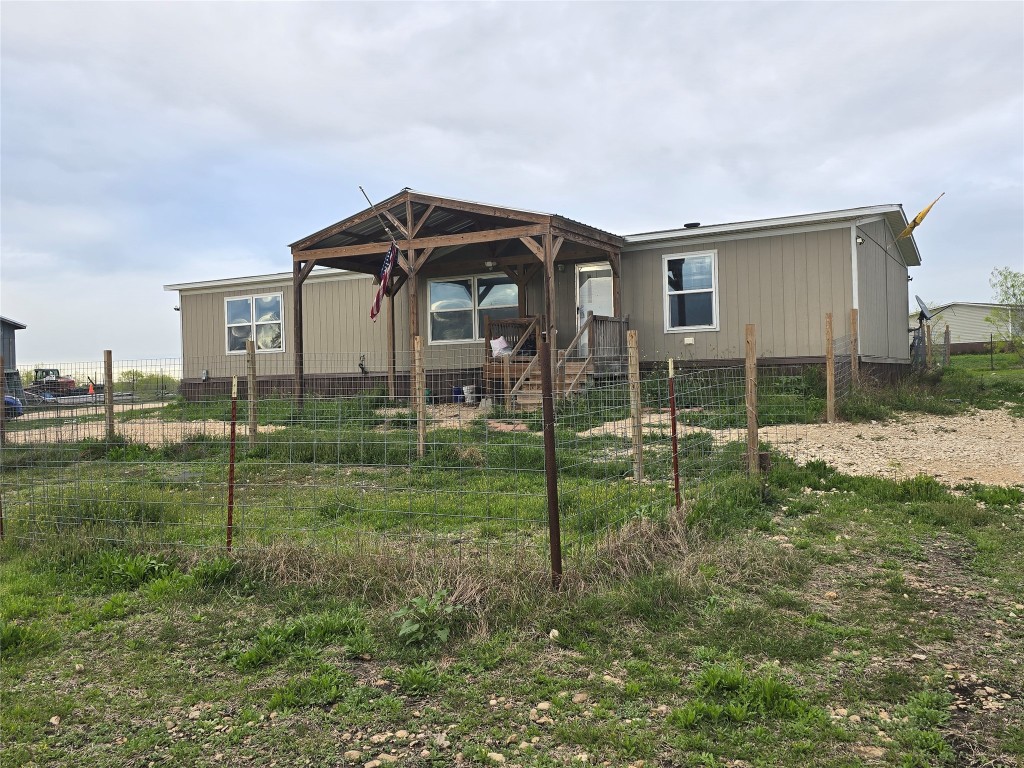 a view of a house with a yard and fence