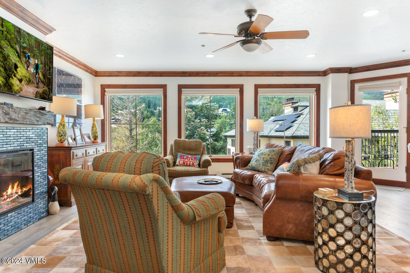 a living room with furniture a fireplace and a floor to ceiling window