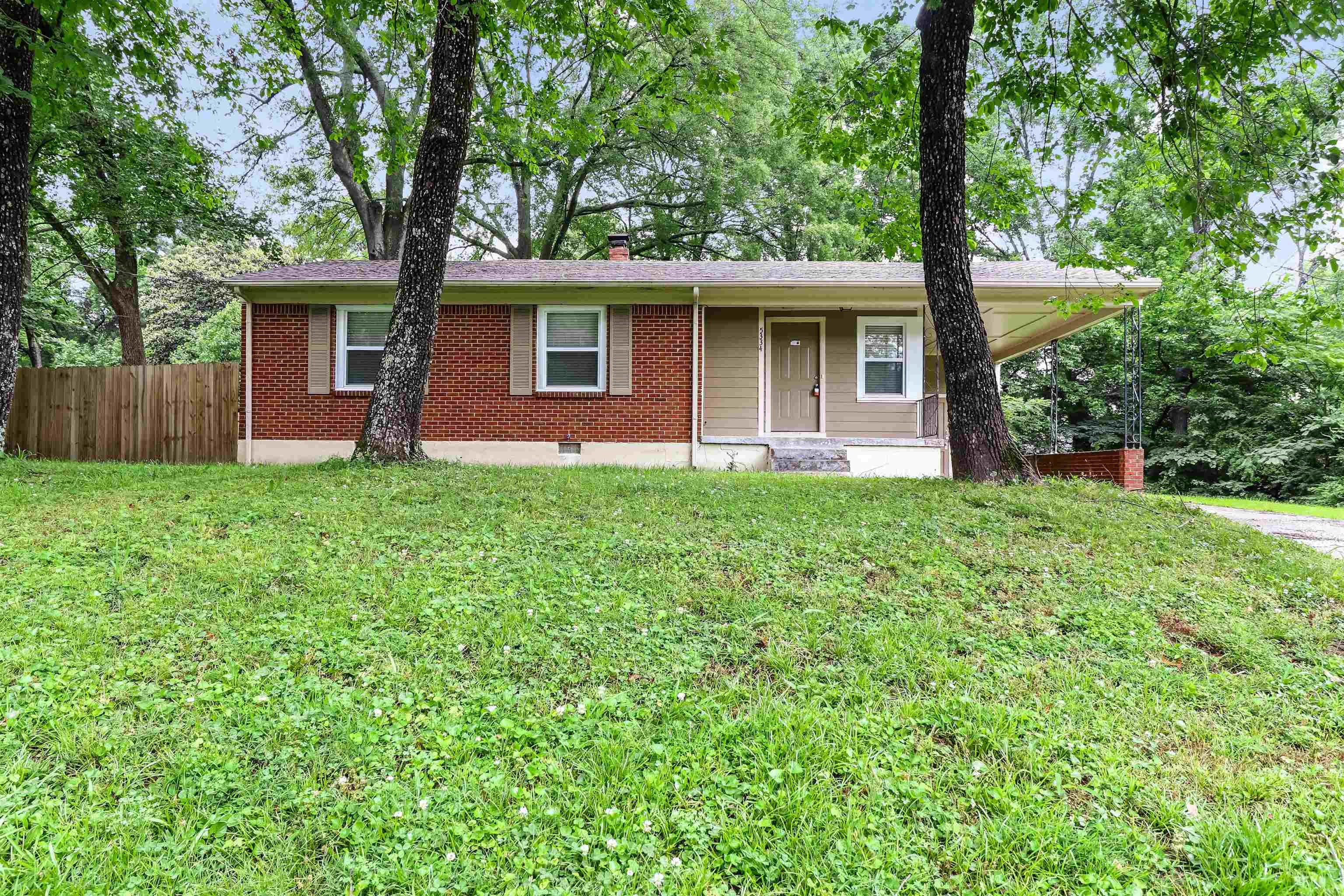 Ranch-style house with a front yard and covered porch