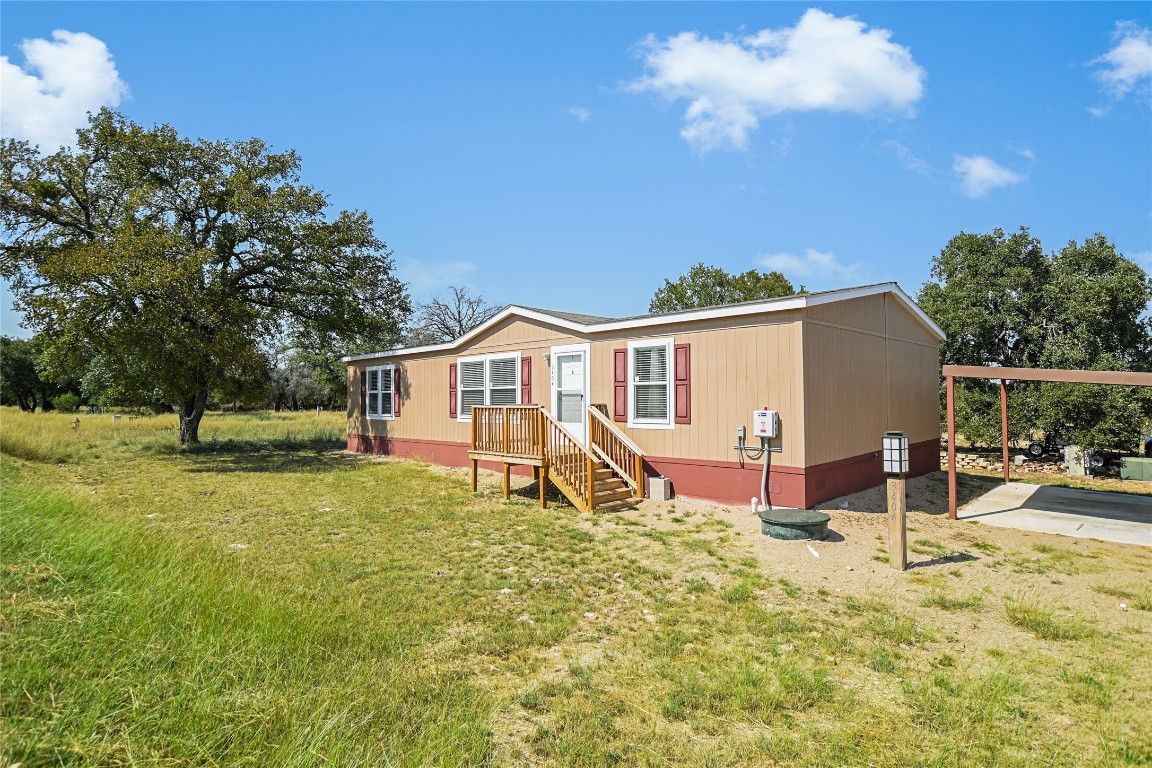 a view of a house with backyard and sitting area