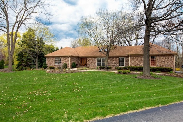 a front view of a house with yard and green space