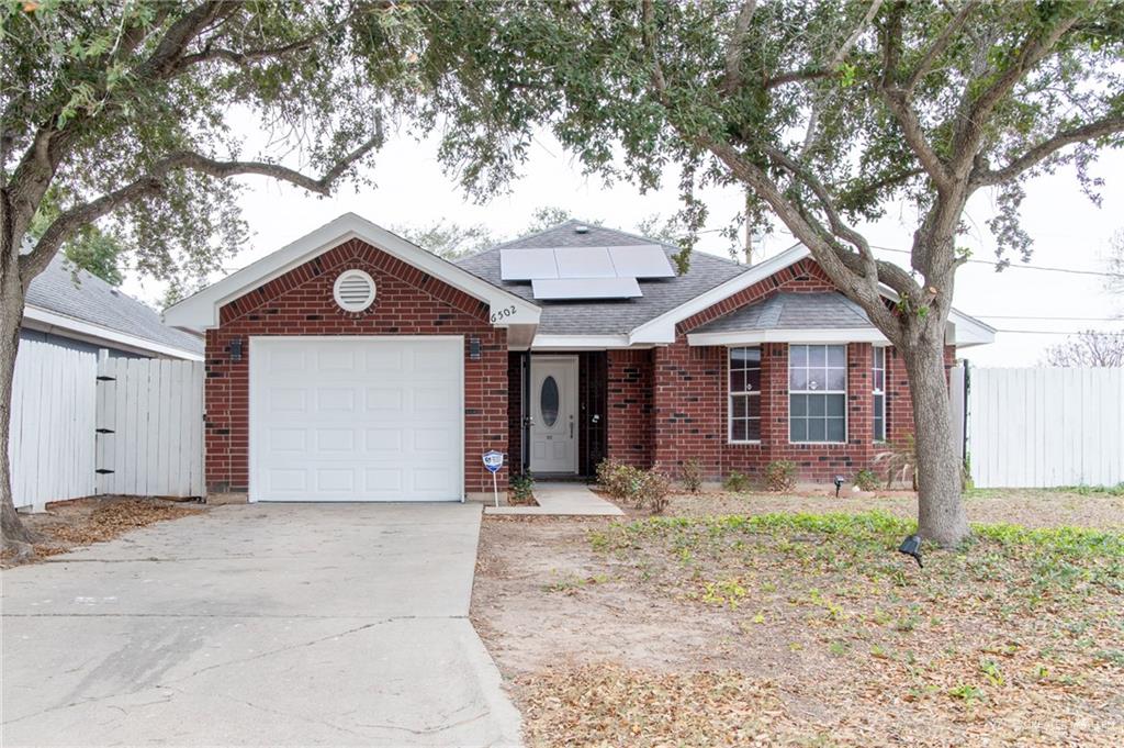 View of front of property with a garage and solar panels