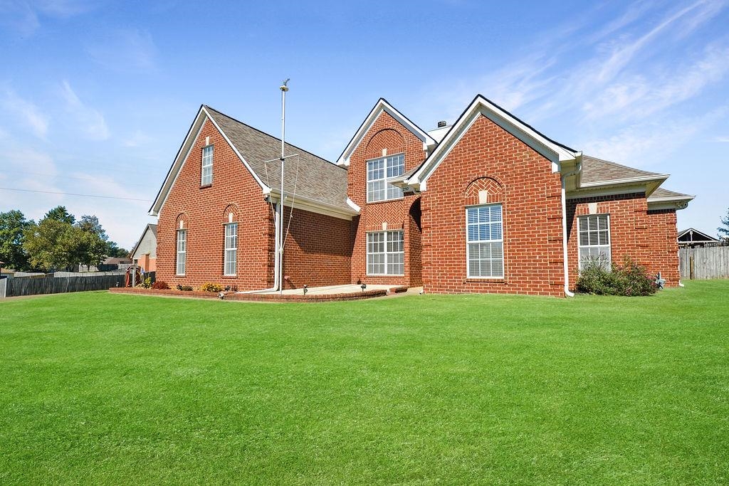 Rear view of property featuring a lawn