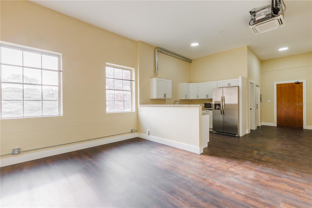 a view of a kitchen with a sink dishwasher oven window and wooden floor