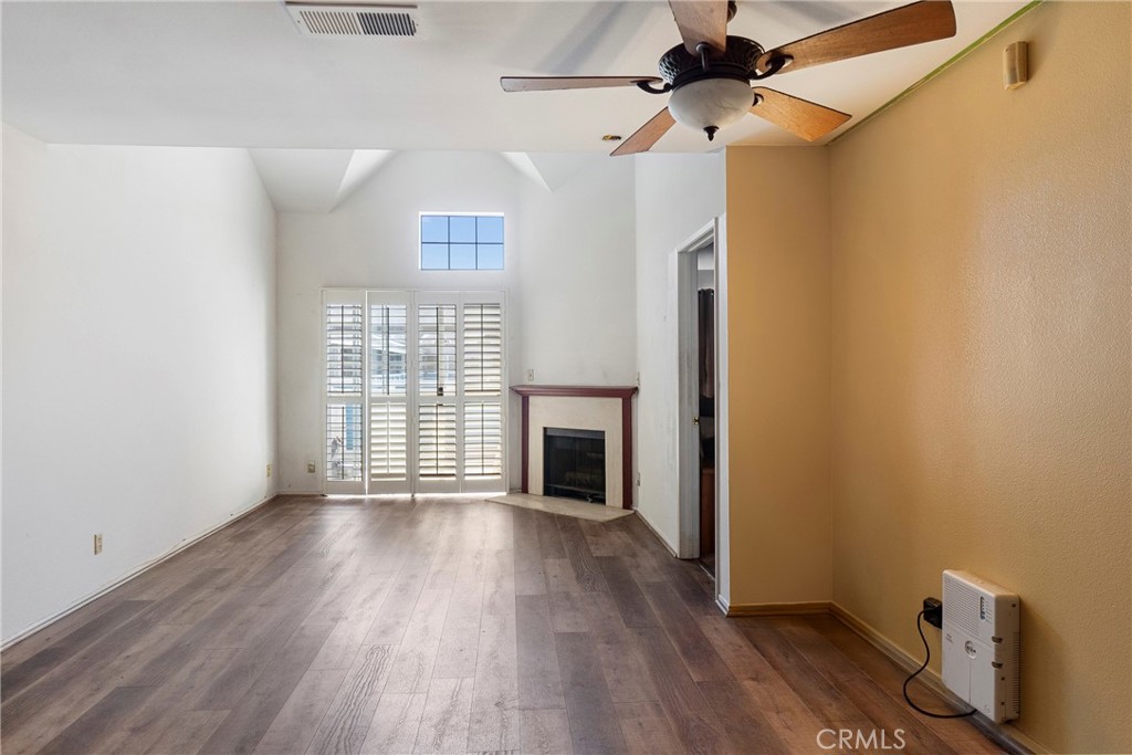 a view of a livingroom with wooden floor a fireplace and window