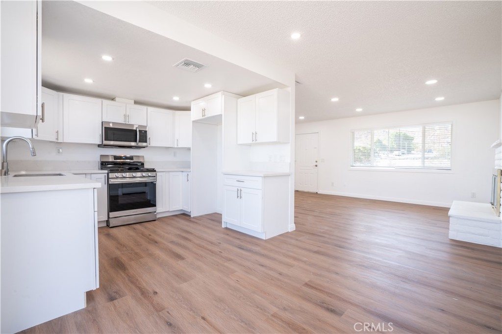 a kitchen with stainless steel appliances granite countertop a stove a sink and a refrigerator