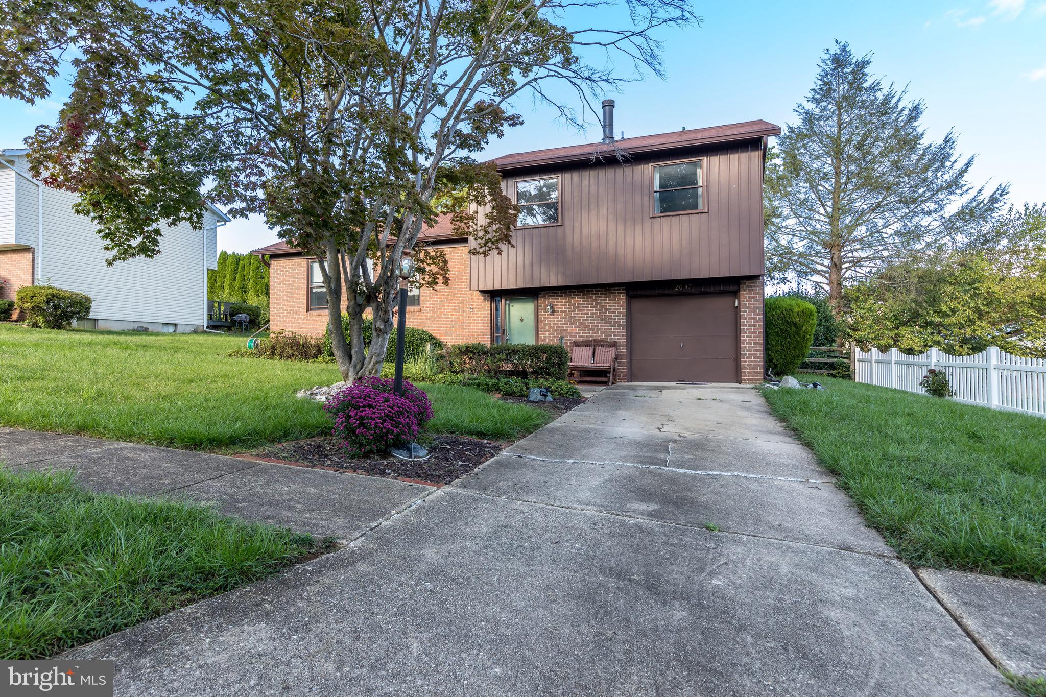 a front view of a house with a yard and trees